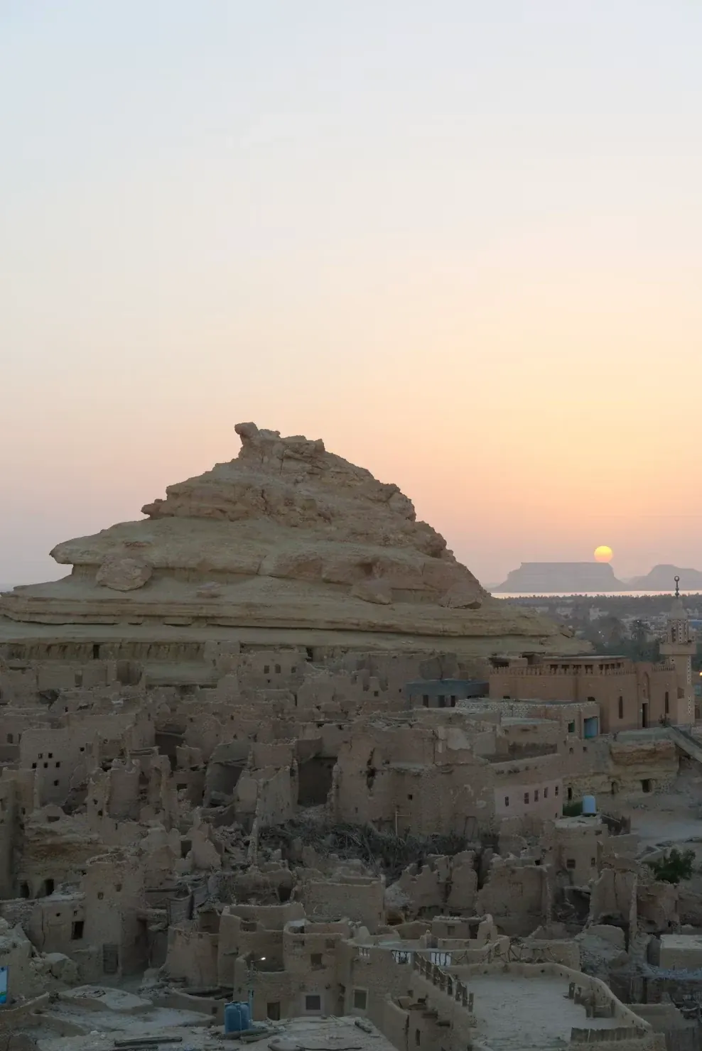 Edificios de adobe de Shali bajo el cielo del atardecer en Siwa