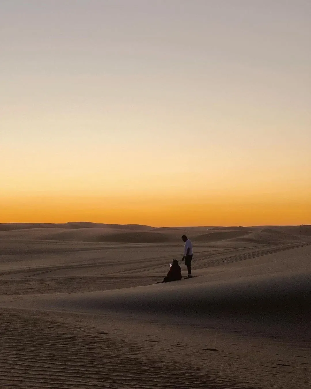 Viajeros sobre una duna durante una salida al desierto de Siwa