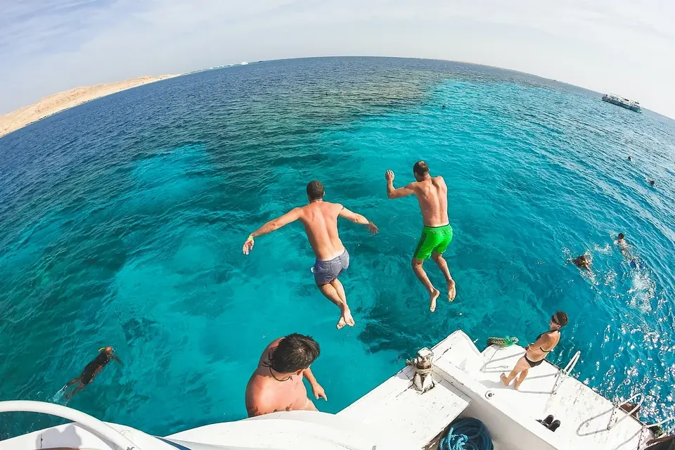 Viajeros saltando desde un barco al mar Rojo